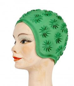 a mannequin head wearing a green hat with flowers on it's side