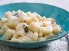 a blue bowl filled with macaroni and cheese on top of a white cloth