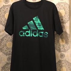 Adidas Tee Shirt Adidas Camo Logo New And Never Used Adidas Sports Shirt With Graphic Print, Adidas Crew Neck Shirt With Letter Print, Adidas Sporty Shirt With Letter Print, Sporty Adidas Shirt With Letter Print, Casual Green Adidas Tops, Adidas Green T-shirt With Graphic Print, Adidas Cotton Graphic Tee Shirt, Adidas Green Short Sleeve T-shirt, Adidas Green T-shirt For Streetwear