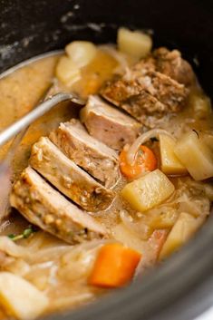 a close up of a bowl of food with meat, potatoes and carrots in it