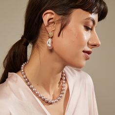 a woman wearing a pearl necklace and earrings