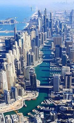 an aerial view of a city with boats in the water and tall buildings on both sides