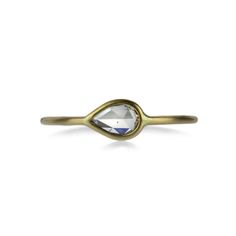 a gold ring with a white diamond on top and an oval shaped stone in the middle