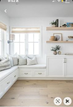 a room with white walls and wooden floors is shown in this image, there are shelves on either side of the window sill