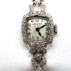 Vintage white gold and diamond Hamilton women's watch. This watch is 14k and contains about .50cts of diamond. This watch has a mechanical movement, runs and keeps great time. Like all of our watches, this also comes with a 1-year guarantee and a 7day return policy that applies to all listings. Thank you for your time and feel free to reach out with any questions! Luxury Antique Watch Accessories For Formal Occasion, Luxury Vintage Jewelry And Watches With Polished Finish, Luxury Vintage Collectible Watch Accessories, Art Deco Diamond Watch With Round Shape, Art Deco White Gold Diamond Jewelry And Watches, Art Deco Diamond Watches With Diamond Accents, Art Deco Diamond Watch For Formal Occasions, Evening Diamond Watch With Art Deco Style, Diamond Art Deco Watch For Formal Occasions