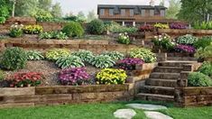 a garden filled with lots of flowers next to a lush green field and stone steps