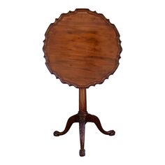 an antique wooden table with two legs and a circular center piece on one end,