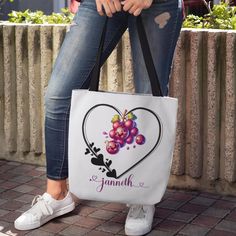 a woman is holding a white bag with grapes on it and the words, i love jamah