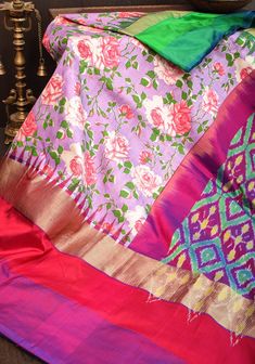 This  printed Pochampalli saree offers a stunning juxtaposition of vivid florals on Lilac, with a wide border of traditional ikkat weaving on the pallu. The body of the saree is Lilac, providing a classic backdrop to the intricate patterning and luxurious grandeur. SILK MARK CERTIFIED This saree is ready to wear with fall and pico done. Handmade silk tassels adorn the pallu and add more grace to it. An unstitched blouse fabric is included. *Note: There may be minor variations in the shade, the t Luxury Traditional Fabric With Pallu, Luxury Unstitched Silk Mark Certified Traditional Wear, Multicolor Paithani Silk Pre-draped Saree For Navratri, Multicolor Ikat Print Pre-draped Saree For Navratri, Navratri Ikat Print Pre-draped Saree, Festive Multicolor Pre-draped Saree With Floral Print, Designer Multicolor Pre-draped Saree With Printed Motifs, Traditional Multicolor Pre-draped Saree With Floral Print, Multicolor Floral Print Saree Set