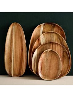 a set of wooden plates and spoons sitting on top of a table next to each other