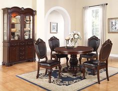 a dining room table with chairs and a china cabinet in the corner on a rug