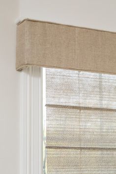 a beige roman blind in front of a window