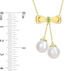 Beautifully feminine, this freshwater cultured pearl and emerald bow necklace is a stunning and unique look. 10K gold. The necklace features a bow-shaped bail set with green emeralds. Two 8.5-9.0mm soft white freshwater cultured pearls suspend from the from the bail. 18.0-inch cable chain with a spring-ring clasp. Formal Pearl Jewelry With Bow, Elegant Bow Necklace For Anniversary, Elegant Green Pearl Necklace For Gift, Formal Fine Jewelry With Bow Detail, Formal Fine Jewelry With Bow, Bow Necklace, Peoples Jewellers, Freshwater Cultured Pearls, Cultured Pearls