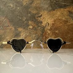 These heart sunglasses are wrapped with black and gold wire.Comes with a cleaning cloth and a pouch to store the sunglasses in. All orders include freebie crystals and stickers. Heart-shaped Glass Sunglasses For Gift, Heart-shaped Glass Sunglasses As Gift, Black Sunglasses With Tinted Lenses As Gift, Black Sunglasses With Tinted Lenses For Gift, Black Sunglasses With Tinted Lenses, Black Tinted Sunglasses As A Gift, Gold Tinted Sunglasses For Festival, Heart-shaped Sunglasses With Uv Protection As Gift, Heart-shaped Sunglasses With Tinted Lenses As Gift