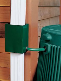 a close up of a green and white door handle on a wooden building with wood siding