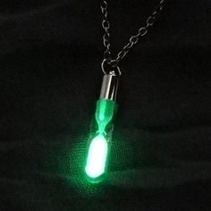 a green light up bottle necklace on a chain