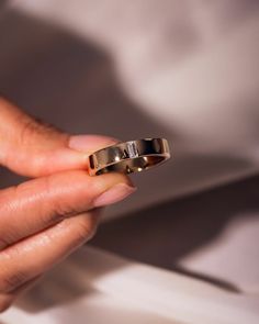 a person holding two wedding rings in their hand