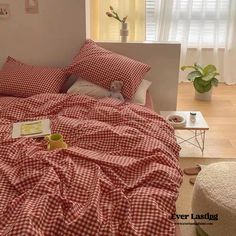 a red and white checkered comforter on a bed