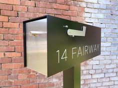 a metal mailbox on the side of a brick building that says 14th farway