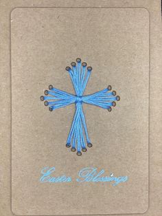 an embroidered blue cross on brown paper with the words easter blessing