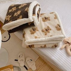 towels and slippers are laying on the floor next to a teddy bear bedding set