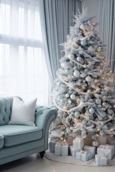 a white christmas tree in a living room next to a couch and window with curtains