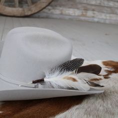 The Cheyenne hat feather is hand constructed with brown and cream feathers for a natural hat accent. Tuck into the band of any hat.Made with a mix of turkey, guinea, and rooster feathers.Approximately 8 inches long, sizes may vary due to being made with natural materials. Natural Feathers Approx. 8 inches - sizes may vary slightly Tuck into the band of any hat! *Hat not included* CA Residents: Prop 65 Warning ↗️ Southwestern Brown Feather Hat Bands, Western Brown Hat Band With Feather Trim, Western Brown Hat Bands With Feather Trim, Southwestern Brown Hat Bands With Feathers, Brown Hat Bands With Feathers For Western-themed Events, Brown Hat Bands With Feathers For Western Events, Feathered Short Brim Hat Bands For Western-themed Events, Brown Felt Hat With Feathers For Rodeo, Feathered Hat Bands For Western-themed Events