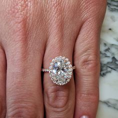 a woman's hand with a diamond ring on top of her finger and an engagement band