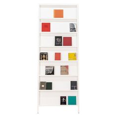 a white book shelf with many books on the top and bottom shelves in different colors