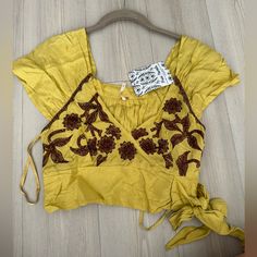 Free People Sahara Embroidered Crop Top In Mustard Yellow Size Xs Nwt- New With Sample Tags. V Neckline Cropped Floral Embroidered Blouse, With Pleated Detailing And A Smocked Back Tie Front Closure Rustic,Boho, Bohemian, Country, Western, Festival, Stagecoach, Embroidered, Crochet, Spring, Summer, Crop, Free People Yellow Embroidered Short Sleeve Top For Spring, Casual Yellow Embroidered Short Sleeve Top, Casual Yellow Embroidered Cotton Top, Yellow Short Sleeve Embroidered Casual Top, Yellow Casual Short Sleeve Embroidered Top, Casual Yellow Short Sleeve Embroidered Top, Yellow Cotton Tops With Floral Embroidery, Fitted Yellow Tops With Floral Embroidery, Spring Yellow Top With Floral Embroidery