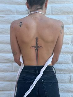 the back of a woman's body with tattoos on it