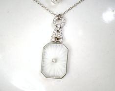 "Offering an exquisite circa 1930s Art Deco/Edwardian rhinestone camphor glass pendant necklace perfect for the bride. It's tough enough to find these Art Deco pendants any longer and this one is SO gorgeous! The rhodium plated pendant on this has an elegant, classic geometric design. The entire pendant (NOT including the rhinestone sections and bail) measures 1 1/8 inch (2.9 cm) long by 3/4 inches (1.9 cm) wide. The pendant features thick frosted (camphor) glass with radial designs cut in the g Vintage Diamond White Pendant Necklace, Vintage Diamond White Pendant Jewelry, Art Deco Diamond White Necklace For Wedding, Diamond White Art Deco Necklace For Wedding, Vintage White Diamond Jewelry, Vintage Diamond White Necklace For Wedding, Art Deco Crystal Jewelry For Vintage Events, Art Deco Crystal Jewelry For Vintage, Victorian White Diamond Jewelry