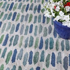 a potted plant sitting on top of a rug covered in blue and green paint