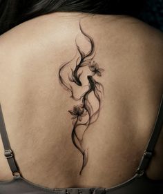 a woman's back with a tattoo design on her left shoulder and lower back