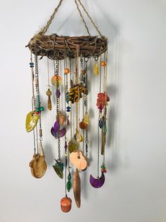 a wind chime hanging from a rope with beads and shells