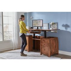 a woman standing in front of a computer desk