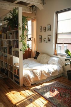 a bed sitting under a window next to a book shelf filled with lots of books