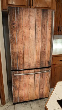 a wooden refrigerator freezer sitting inside of a kitchen