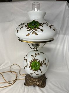 a white table lamp sitting on top of a bed