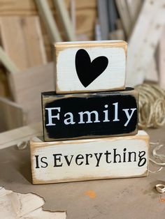 two wooden blocks with the words family is everything written on them in black and white