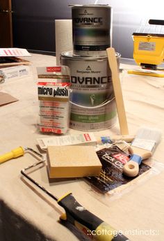 the table is covered with paint, tools and other items that are sitting on it