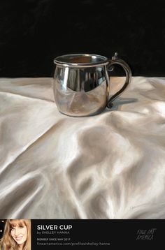 a silver cup sitting on top of a white cloth