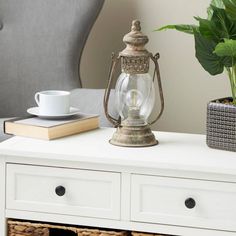 a white table topped with drawers and a lamp