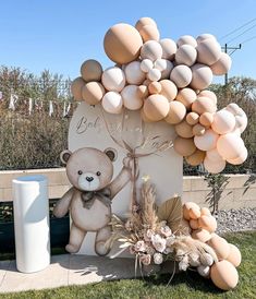 a teddy bear balloon arch with balloons attached to it