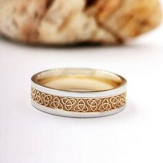 a close up of a ring on a table with a piece of bread in the background