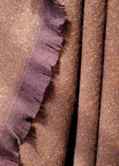 the fabric is brown and purple with some fringes on it's sides,