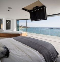 a bedroom with a large bed and a flat screen tv mounted to the wall above it