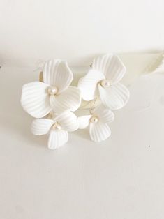 three white flowers with pearls on them