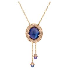 Enchanting tanzanite necklace from our Starlight Collection. -Handmade of 18K rose gold. -Center Stone: deep purplish blue cabochon cut tanzanite, 73,21ct. -Handset with 332 rose-colored sapphires, ca 10ct total. -2 dangling cabochon cut tanzanites, 8ct total -The length of the necklace and dangling tanzanites is adjustable by pressing the button in the back and pulling on either. Imagine hot, liquid magma rising from the depths and slowly cooling. Only a few million years later, after some tric Luxury Tanzanite Pendant Necklace, Blue Sapphire Pendant Designs, Tanzanite Pendant Design, Colored Sapphires, Tanzanite Pendant, Blue Sapphire Pendant, Tanzanite Necklace, Jewellery Art, Tanzanite Jewelry