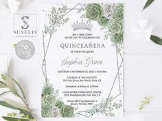 a wedding card with succulents and greenery on it, next to some flowers